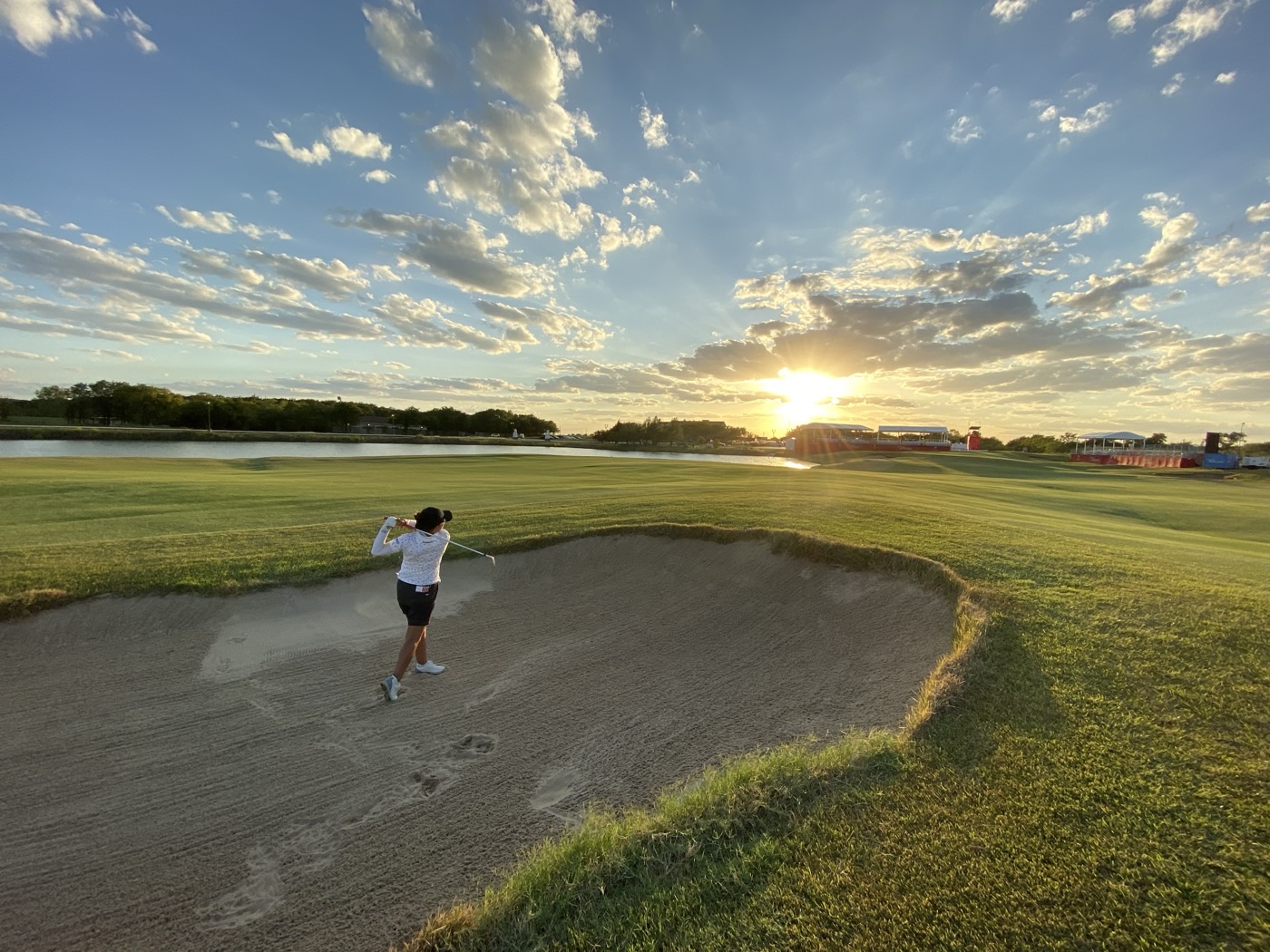 夕日を背にバンカーからショットを打つ横峯さくら